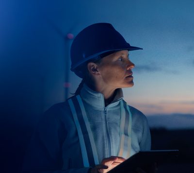Operário com capacete azul e colete refletivo